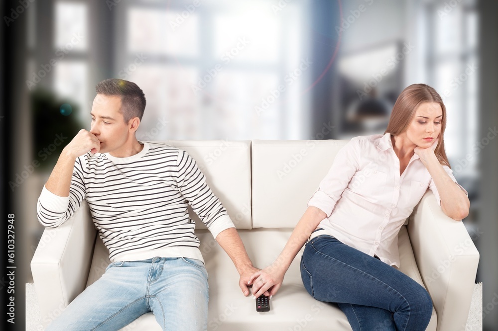 Unhappy sad couple sitting on a couch Unhappy sad couple sitting on a couch