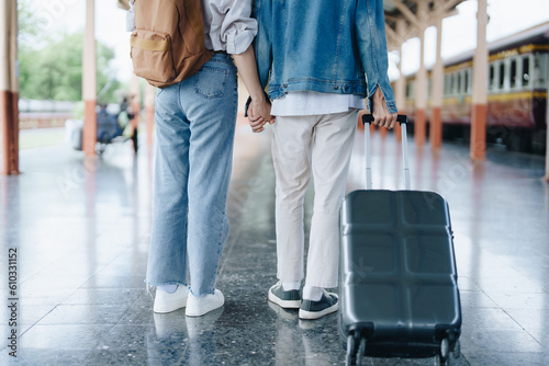 Tourist couples showing their love and happiness in a sweet way while waiting for their journey at the train station.