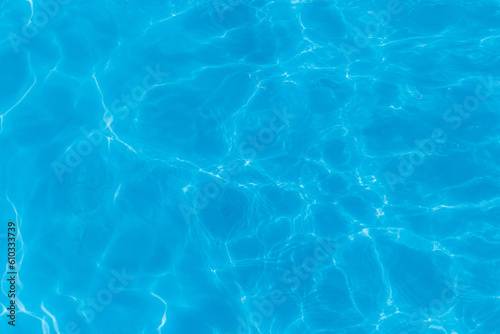Blue clear pool water with abstract pattern of reflection and wave surface transparent background © Andrey