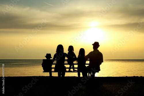 A happy family in nature by the sea on a trip silhouette