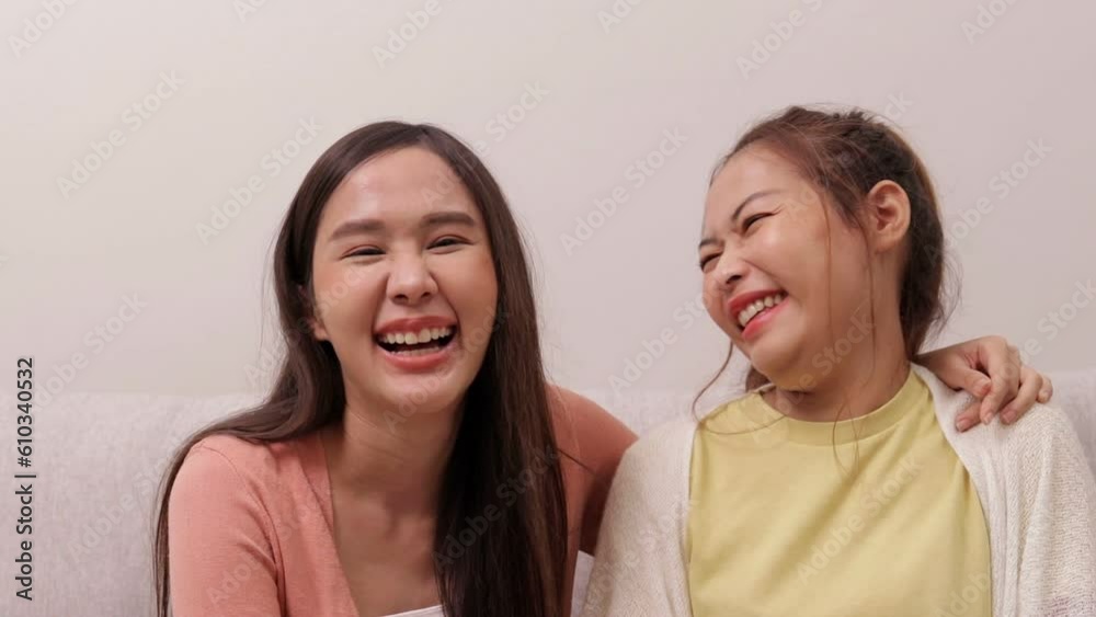 Two asian women chatting having fun smiling happily in the living room in the house. Two asian women chatting having fun smiling happily in the living room in the house.