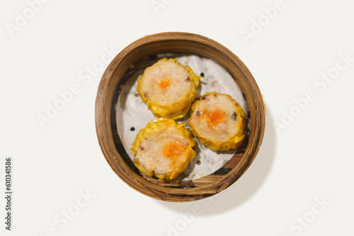 Delicious steamed dumpling dimsum or siomay on bamboo steams isolated on white background. dimsum or dumpling is a snack from China and Hong Kong is made from chicken, pork, shrimp. photo