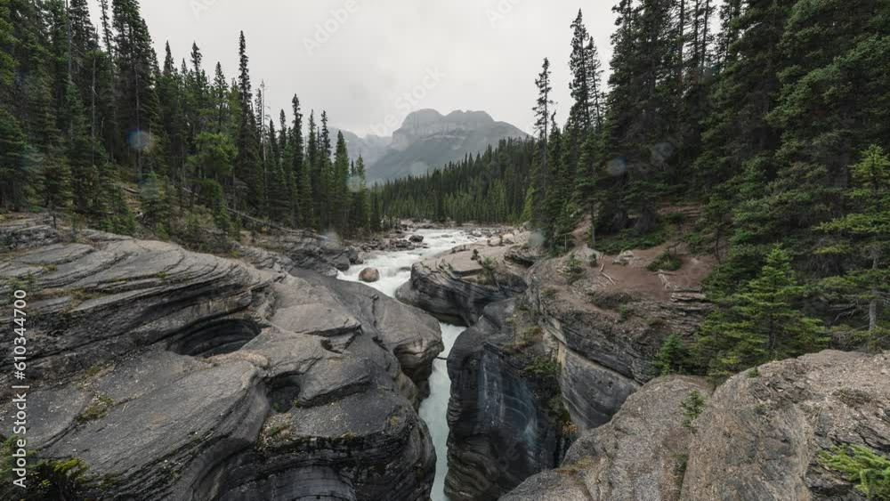 Beautiful Mistaya Canyon with stream rapids in pine forest on gloomy day at Icefields Parkway Beautiful Mistaya Canyon with stream rapids in pine forest on gloomy day at Icefields Parkway