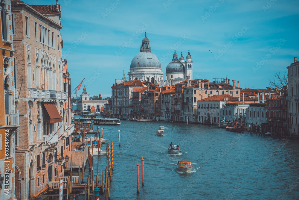 A cinematic scene of Basilica Santa Maria della Salute in Venice with boats passing in the canal