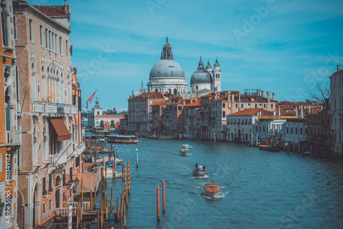 A cinematic scene of Basilica Santa Maria della Salute in Venice with boats passing in the canal © ABDELRAHMAN