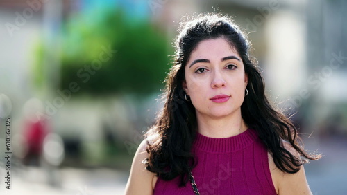 Foto Portrait of a young woman turning head with stoic surprise toward camera standin