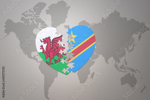 puzzle heart with the national flag of democratic republic of the congo and wales on a world map background.Concept.