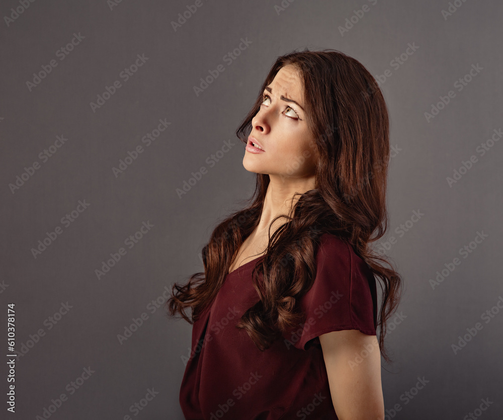 Beautiful thinking  fun grimacing business woman have an strategy idea looking up on grey studio background with empty copy space for text. Closeup - obrazy, fototapety, plakaty 