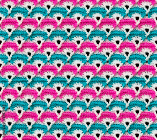 Seamless knitted texture. The pattern in the form of fans is crocheted from colored yarn. Acrylic blanket.