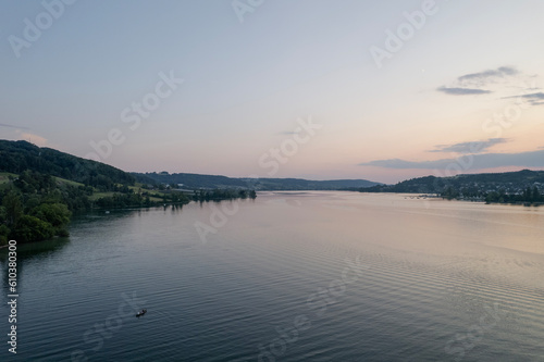 Fototapeta Naklejka Na Ścianę i Meble -  aerial footage of sunset over the lake in switzerland and a kayak in the wayer