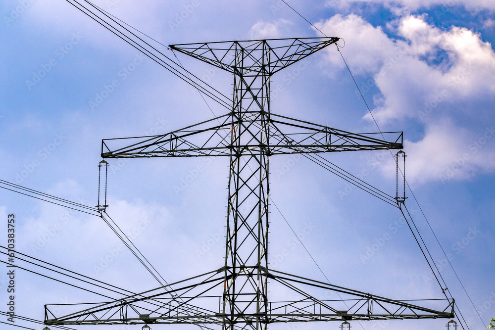 Power transmission tower, power line against the blue sky with clouds Power transmission tower, power line against the blue sky with clouds