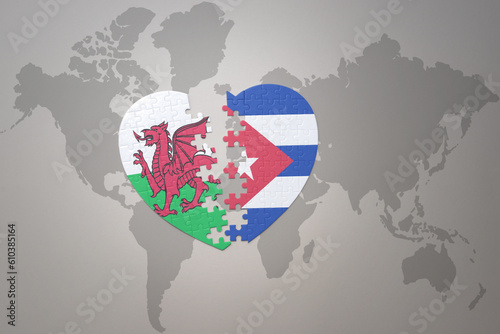 puzzle heart with the national flag of cuba and wales on a world map background.Concept.