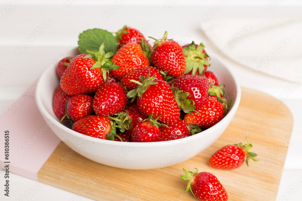 Fresh strawberries in bowl on wooden table Fresh strawberries in bowl on wooden table
