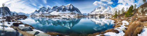 A picturesque alpine valley with a calm lake, framed by snow-capped mountains and clear skies. Ideal for moments of peaceful discovery or a strong graphic image. Generative AI