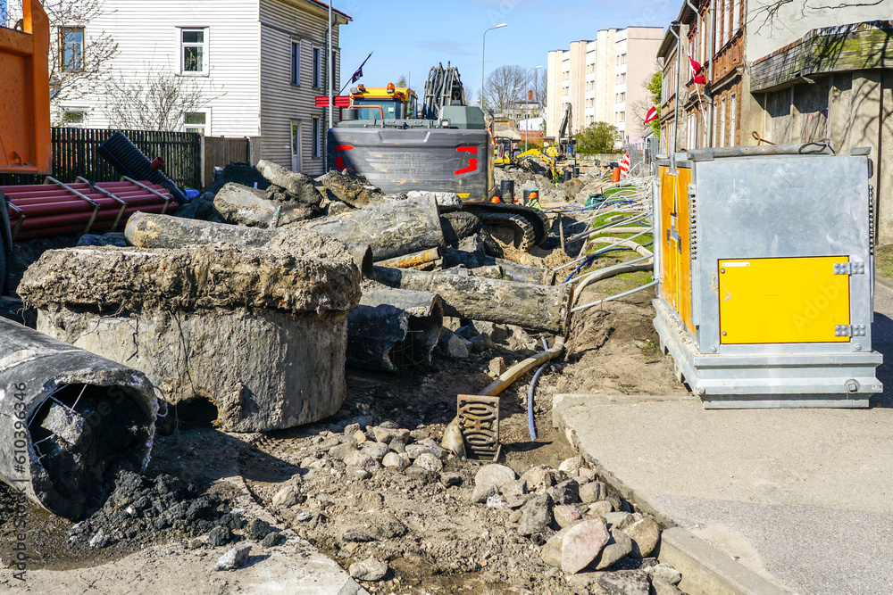 Underground communications replacement site with dewatering system and excavator on a city street