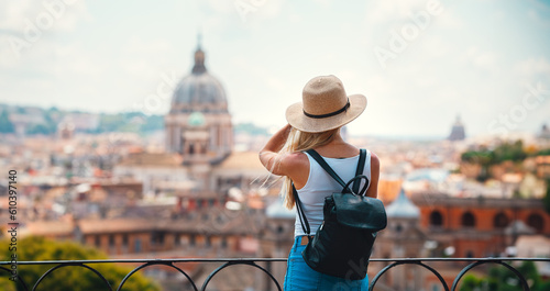 Young attractive smiling girl tourist exploring new city at summer