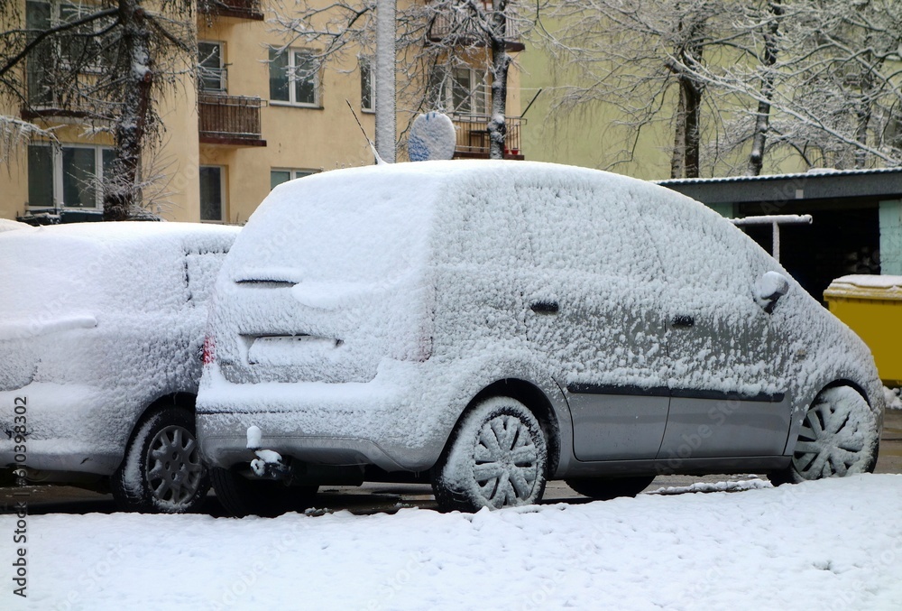 Car lightly covered with snow in April at the beginning of spring