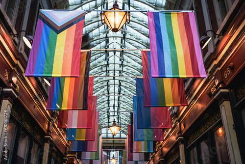 Photography Different LGBTQ pride and rainbow flags hanginging in two rows in city market space