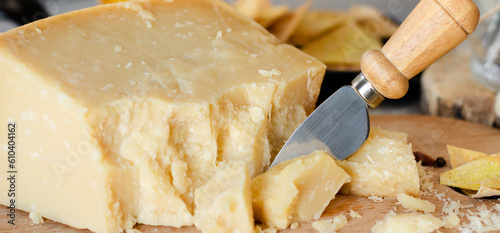 Parmesan cheese cut with knife. Italian food background.