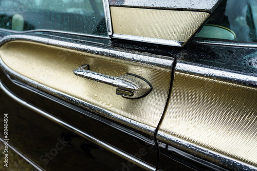 Door handle of a retro car in raindrops, close-up. © Sergey Kohl