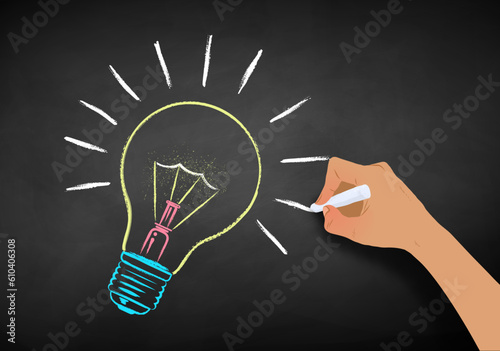 Vector chalk illustration of hand drawing light bulb on chalkboard background.