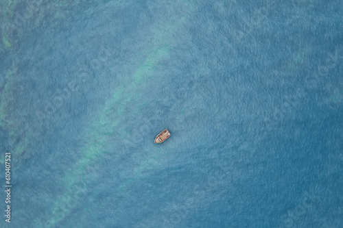 red fishing boat floating in the middle of the sea