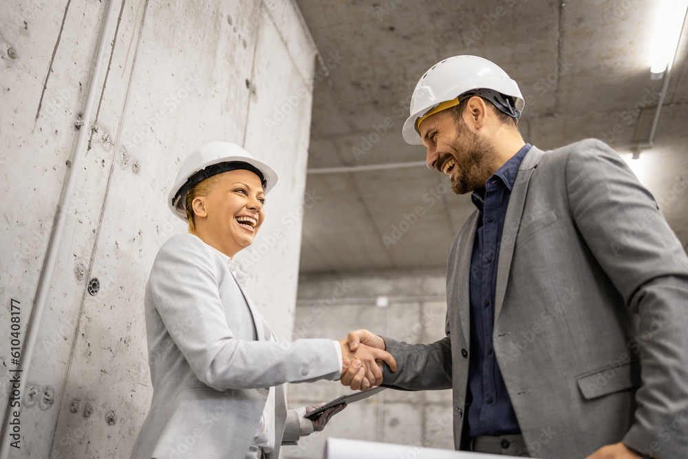 Architect shaking hands with construction engineer for successful cooperation. Architect shaking hands with construction engineer for successful cooperation.