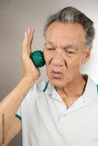 Mature man holding and squeezing massage therapy spike balls 