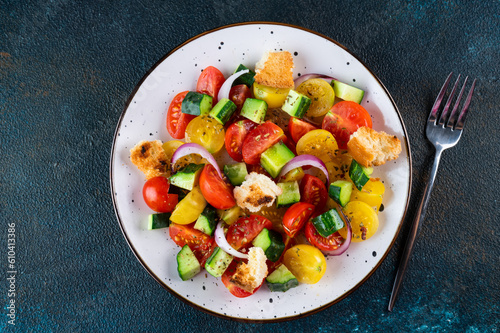 Vegetarian salad Panzanella with tomatoes, onion and bread Croutons. Dark background. Top view. Italian salad