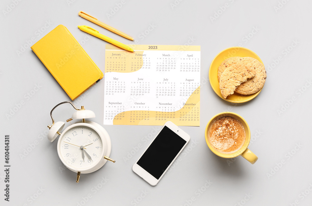 Composition with calendar, mobile phone, alarm clock, cup of coffee and cookies on grey background Composition with calendar, mobile phone, alarm clock, cup of coffee and cookies on grey background