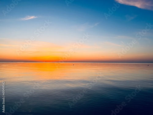 Orange sea horizon  evening seascape background  natural colors  calm water surface reflection