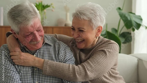 Senior adult mature couple hugging at home. Mid age old husband and wife embracing with tenderness love enjoying sweet bonding wellbeing. Grandmother grandfather together. Family moment love and care