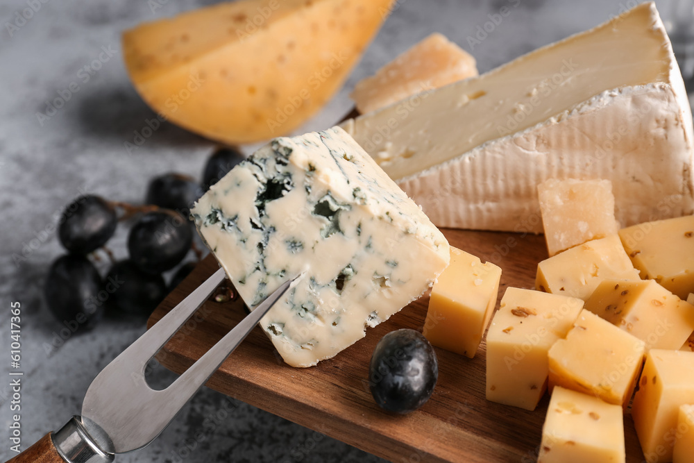 Fototapeta premium Fork with pieces of tasty cheese on table, closeup