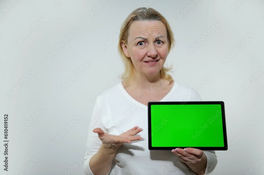 Young female with negative expression on face holding chromakey board and looking at camera. Chromakey with cross for tracking good for inserting some pictures commercial inscription Young female with negative expression on face holding chromakey board and looking at camera. Chromakey with cross for tracking good for inserting some pictures commercial inscription