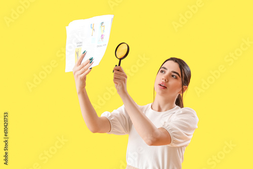 Young woman with magnifier ...