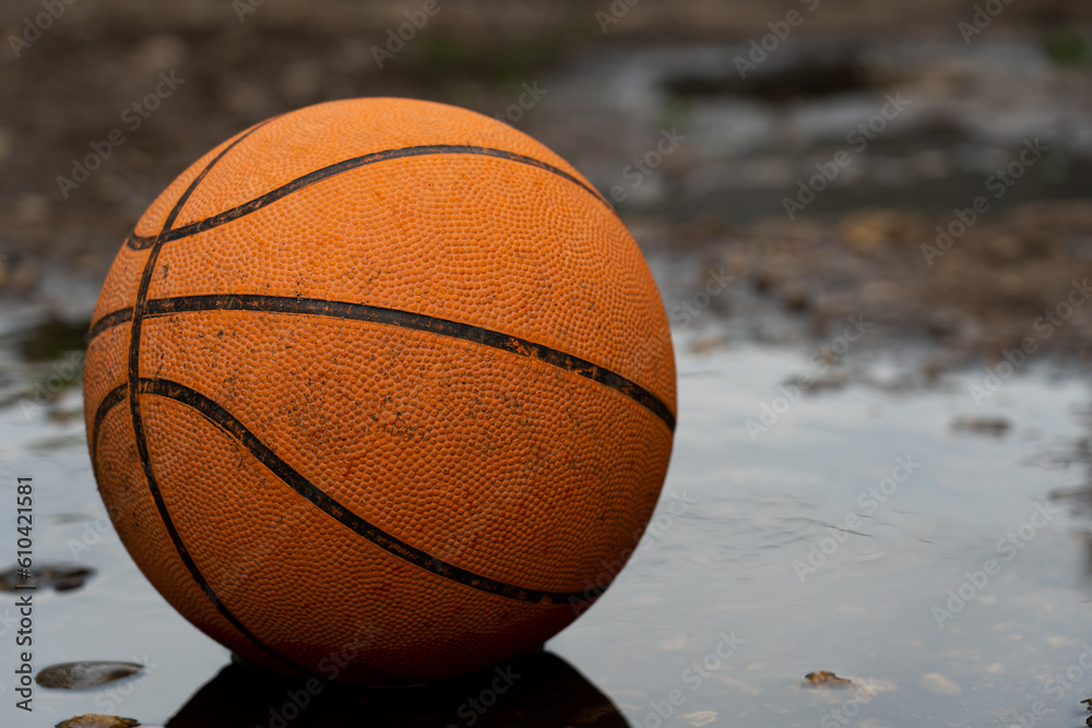 Basketball ball in puddles on the street