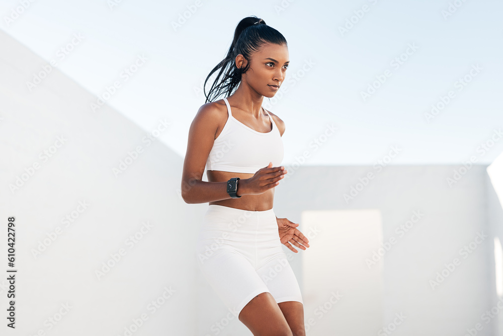 Slim woman in white fitness attire warming up outdoors. Young female  jumping up and down. Stock Photo