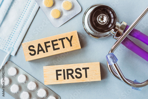 SAFETY FIRST text on a wooden blocks on a table next to a stethoscope
