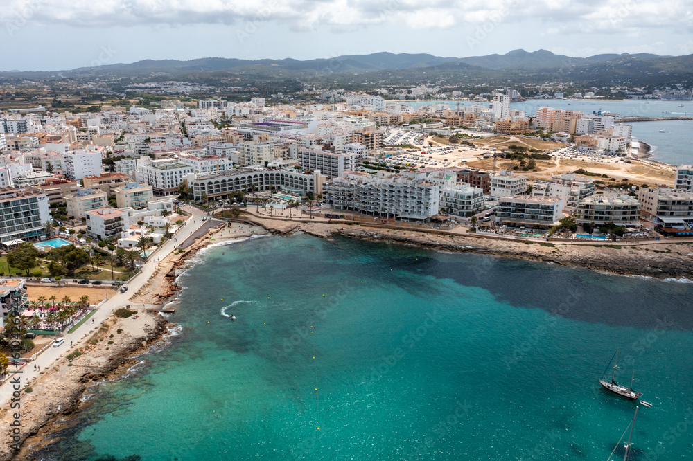 Aerial drone photo of a beach in the town of Sant Antoni de Portmany on the island of Ibiza Balearic Islands Spain showing the ocean front and Cala Alto de Porta beach in the summer time.