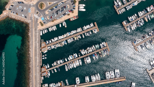 Straight down aerial drone photo of the town of Sant Antoni on the island of Ibiza in the Balearic Islands Spain showing the boating harbour with parked up boats by the car park in the bay. photo