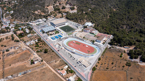 Aerial drone photo of a sports stadium in the town of Sant Antoni de Portmany on the island of Ibiza in the Balearic Islands Spain, showing the running track stadium in the summer time. photo