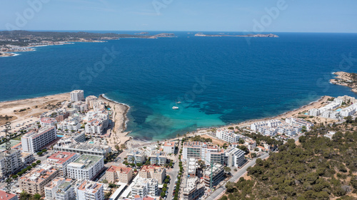 Fototapeta Naklejka Na Ścianę i Meble -  Aerial drone photo of a beach in the town of Sant Antoni de Portmany on the island of Ibiza Balearic Islands Spain showing the ocean front and Cala Alto de Porta beach in the summer time.