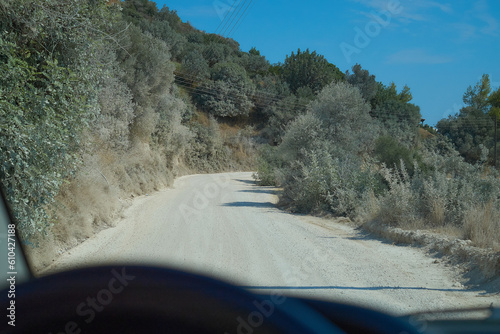 Górska droga gruntowa widziana przez szybę samochodu photo