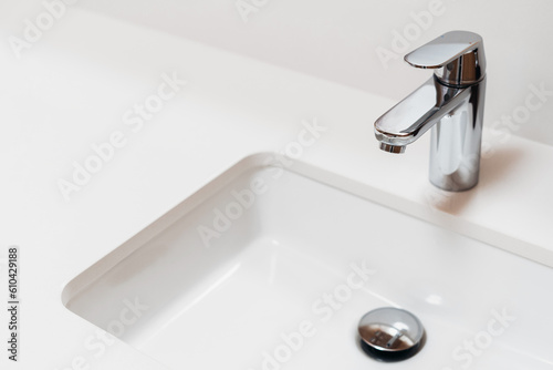white modern sink and chrome faucet in bathroom