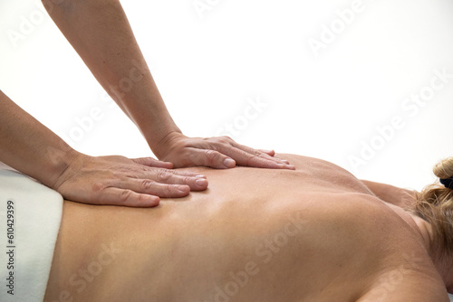 Hands of a physiotherapist working on the back of a blonde woman, on a white background