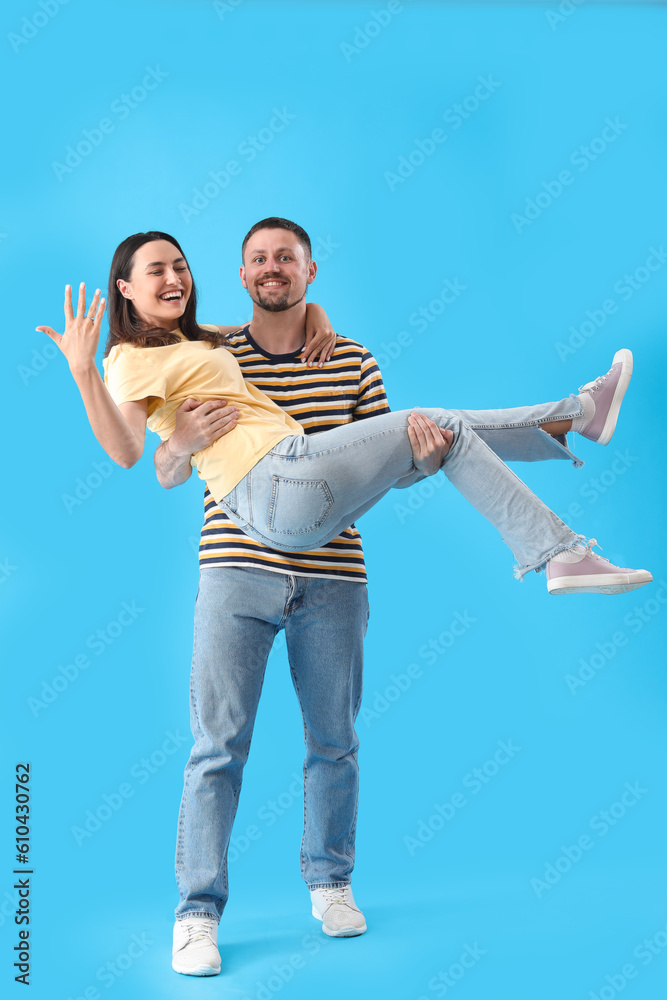 Happy engaged couple on blue background Happy engaged couple on blue background