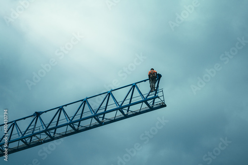 Construction worker crane operator assembling a crane