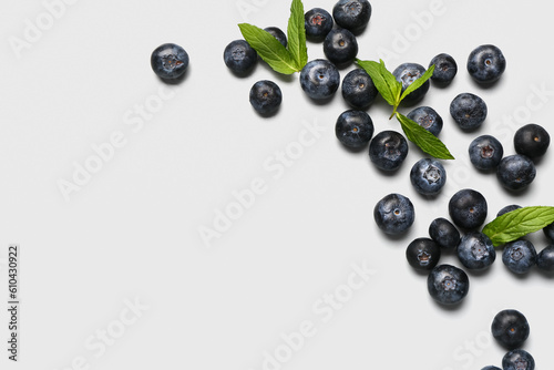 Fresh blueberries and mint on grey background