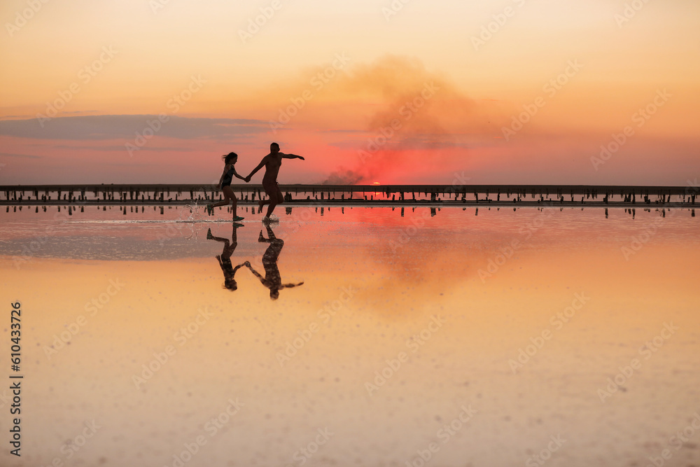 Happy Fathers day. Silhouette of young dad and child daughter having fun running together on beach on sunset. Family summer travel holiday. Concept of family values. International Children's Day