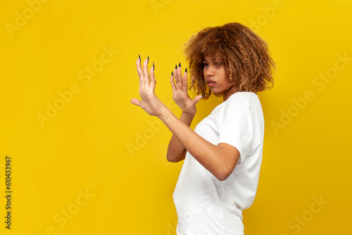young curly american girl refuse and avoid with hands on yellow isolated background  african woman shows refusal